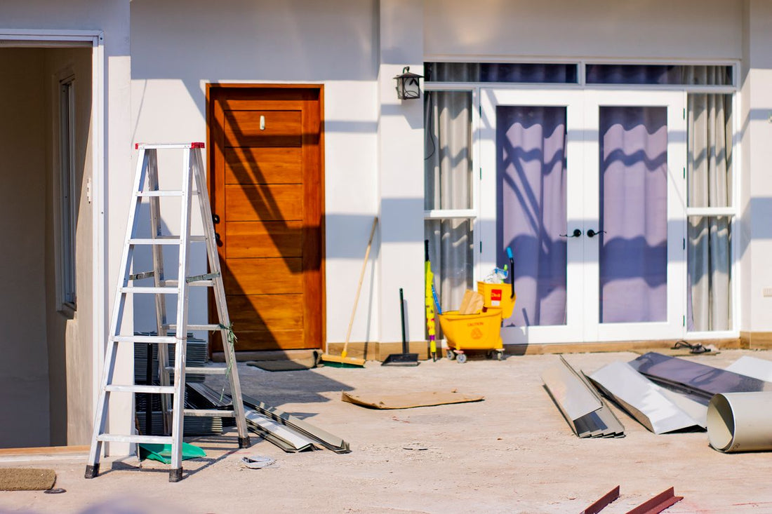 Front entrance of a house mid-renovation with tools and materials scattered around