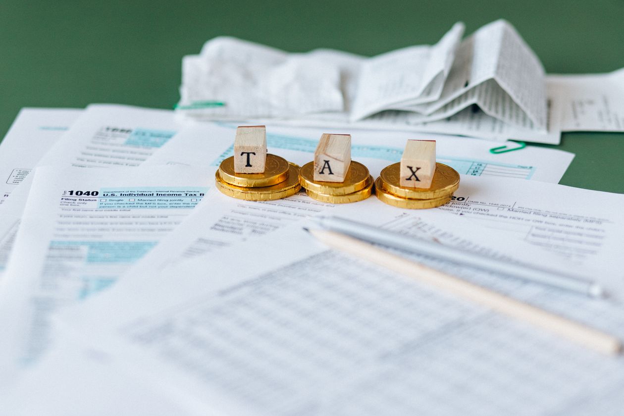 Tax documents and calculator on a wooden desk — property flipping tax