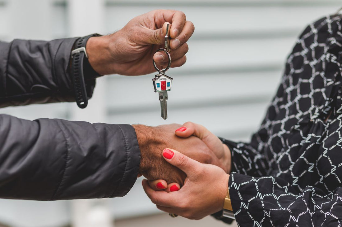 Person holding silver house key — selling property without an agent